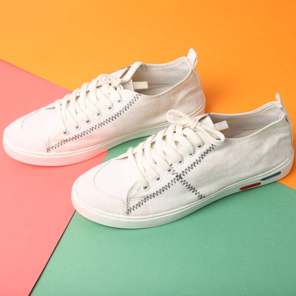 Hvide sneakers på farvet baggrund